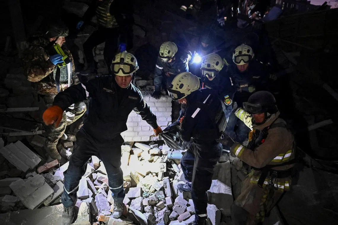 Rescuers carry the body of a person killed in a Russian air strike, at the site where an apartment building was hit, amid Russia's attack on Ukraine, in Zaporizhzhia, Ukraine November 7, 2024. REUTERS/Stringer