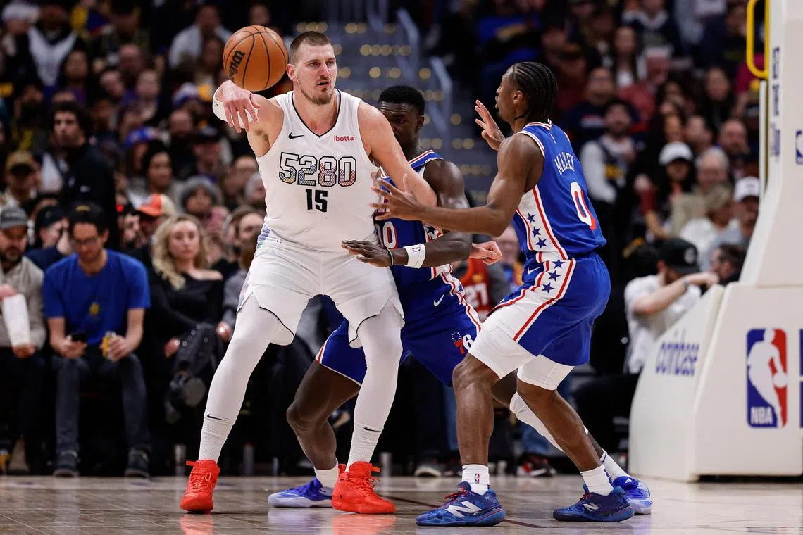 Denver Nuggets centre Nikola Jokic controlling the ball under pressure from Philadelphia 76ers centre Adem Bona (centre) and guard Tyrese Maxey in the third quarter at Ball Arena on Jan 21. He registered 27 points with 13 rebounds and 10 assists to help the Nuggets to a 144-109 NBA win.