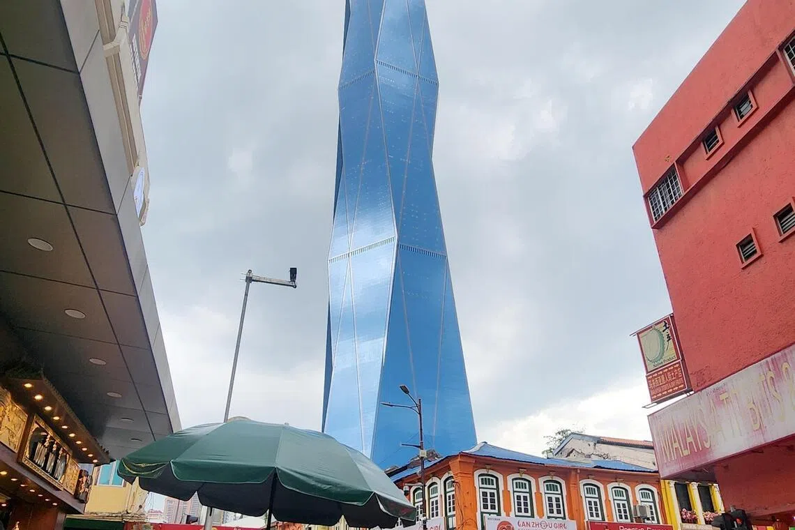 The blue Merdeka 118 skyscraper soars above Chinatown in central Kuala Lumpur.