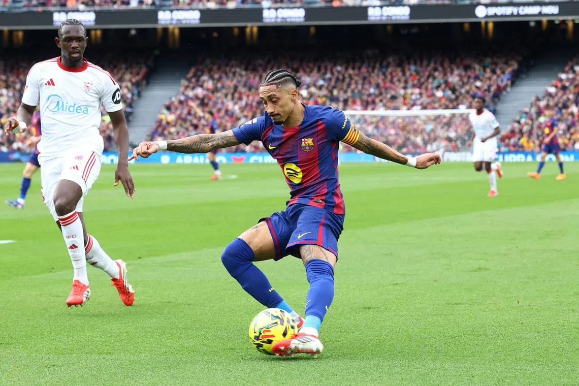 Soccer Football - LaLiga - FC Barcelona v Sevilla - Spotify Camp Nou, Barcelona, Spain - March 15, 2026 FC Barcelona's Raphinha in action with Sevilla's Tanguy Nianzou REUTERS/Albert Gea