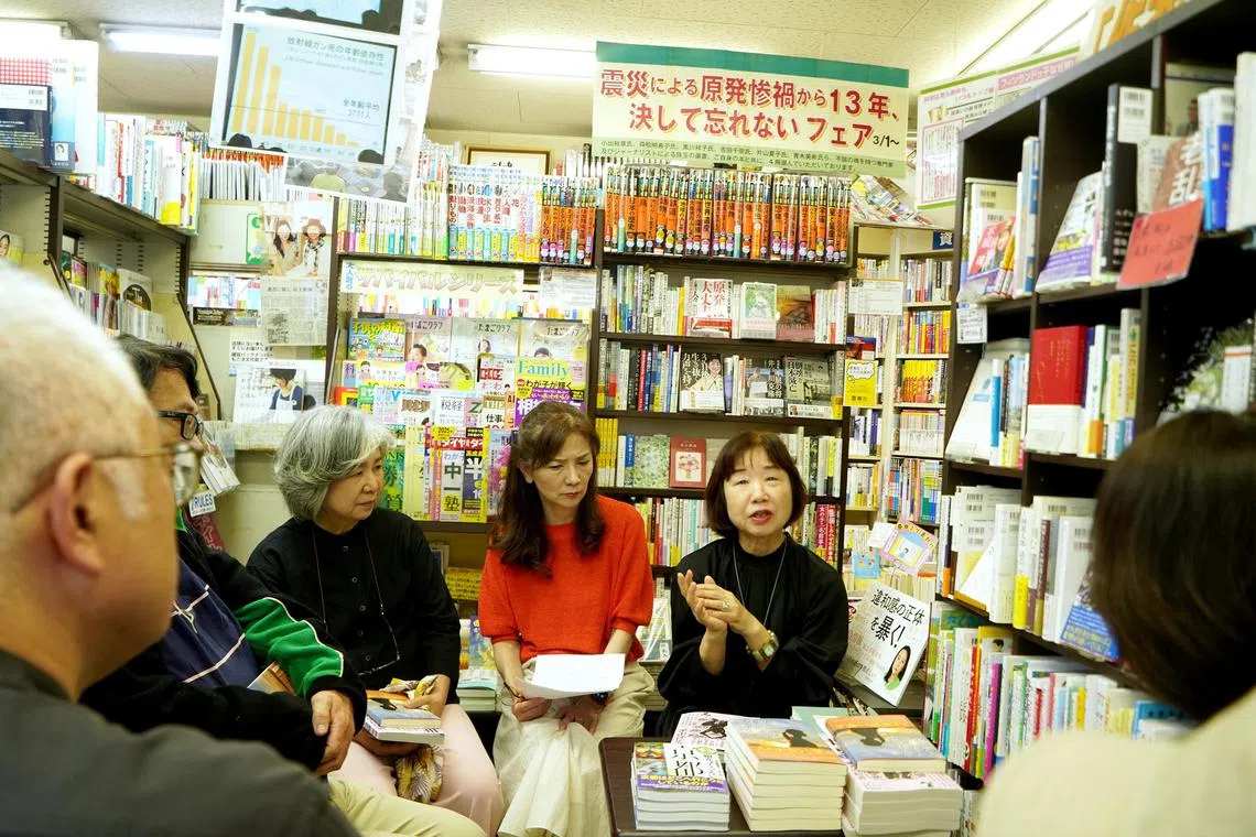 Ms Tomoko Futamura (in red), 64, second-generation owner of the Ryushokan Book Store in Osaka, listens as author Mitsuko Hirai interacts with readers at a session hosted at the bookstore. 
