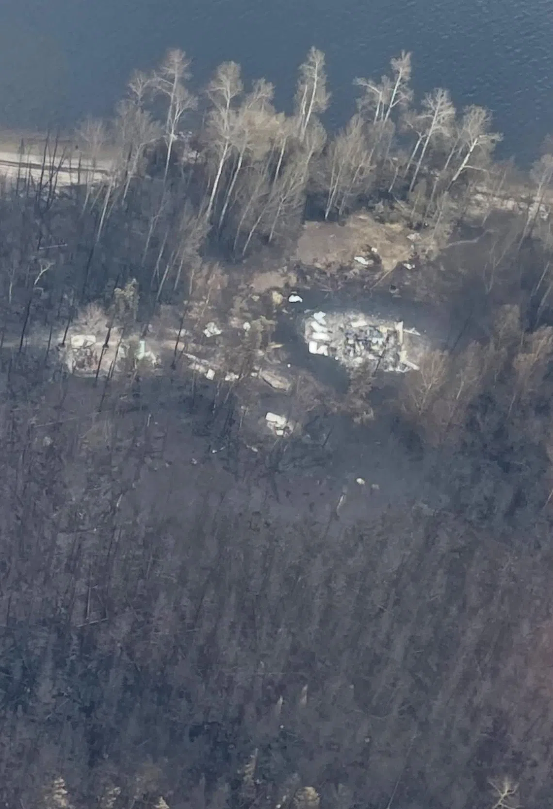 Buildings in the Whitewater Lake First Nation community are seen after it was destroyed by a wildfire, during a flight over the area which is 250 kilometres north of Thunder Bay, Ontario, Canada July 18, 2026. Nishnawbe Aski Nation/Handout via REUTERS.