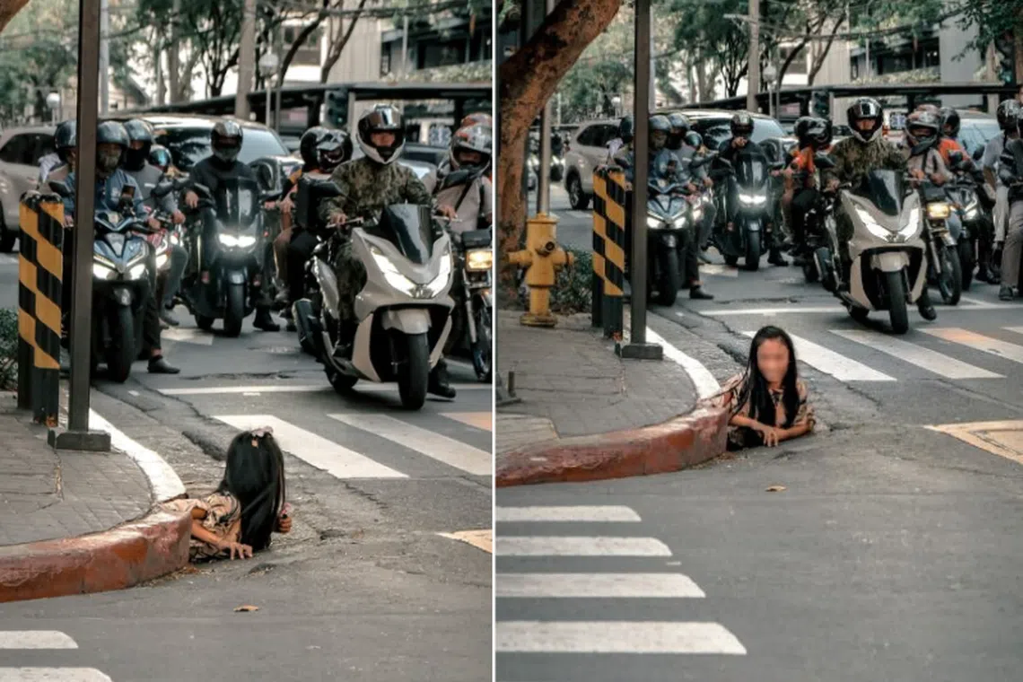 A street photographer takes photos of a woman crawling out of a storm drain in Manila’s main financial district.