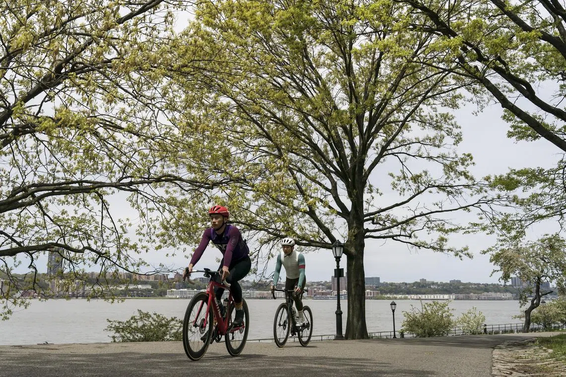Cyclists ride along the Hudson River Greenway in Riverside Park in New York, May 8, 2022.