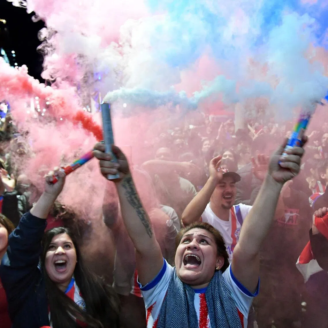 Paraguayan fans celebrating during a live  telecast of the 2026 FIFA World Cup football match between Germany and Paraguay in Asuncion.