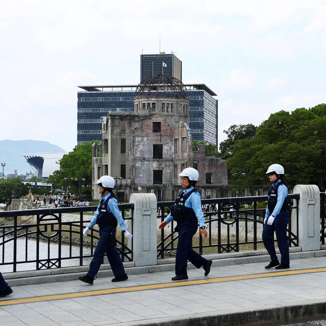 Female police officers walk around the Hiroshima atomic bomb dome.