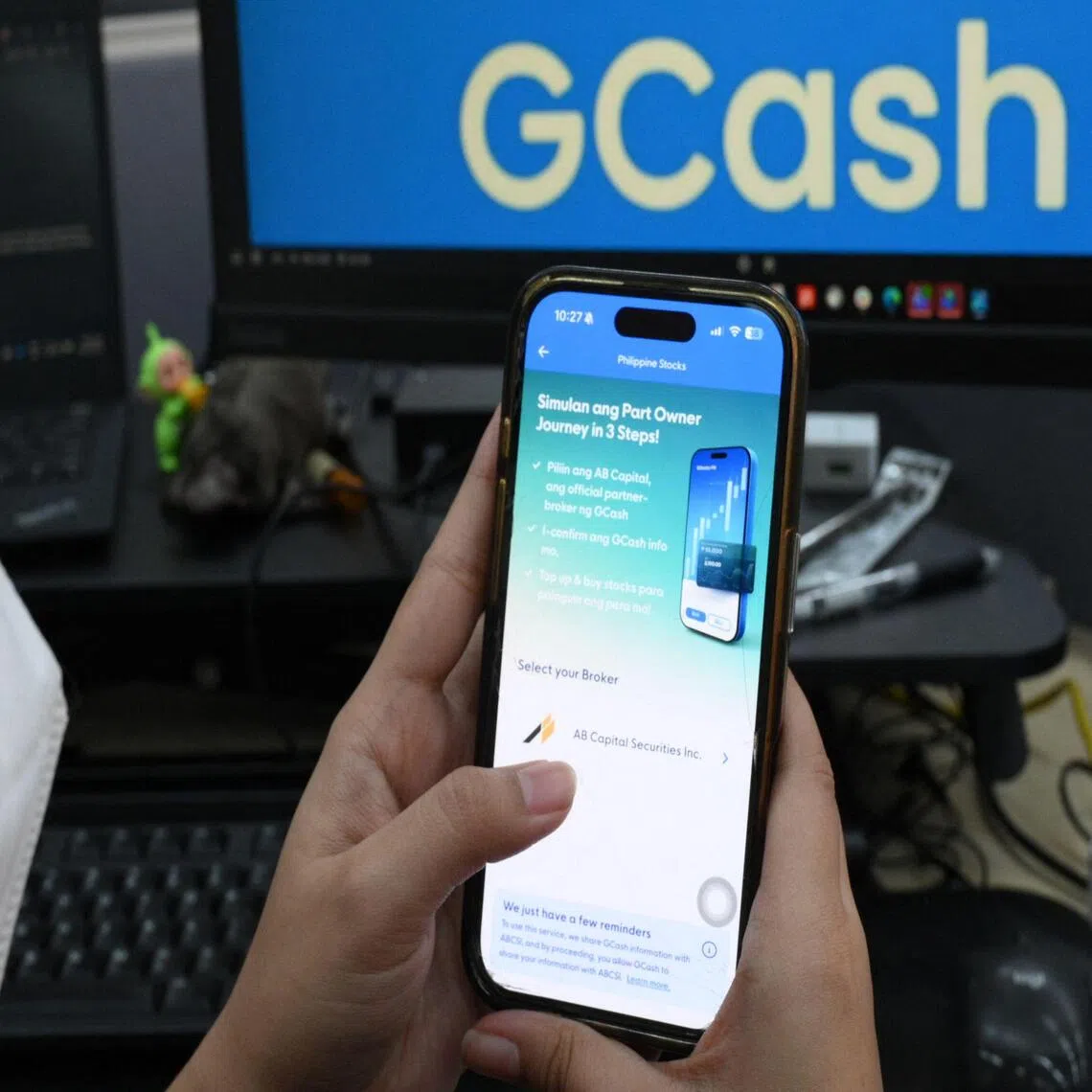 A woman checks the stock price offer of Mynt, the parent company of GCash, at an office in Manila on Oct 19.