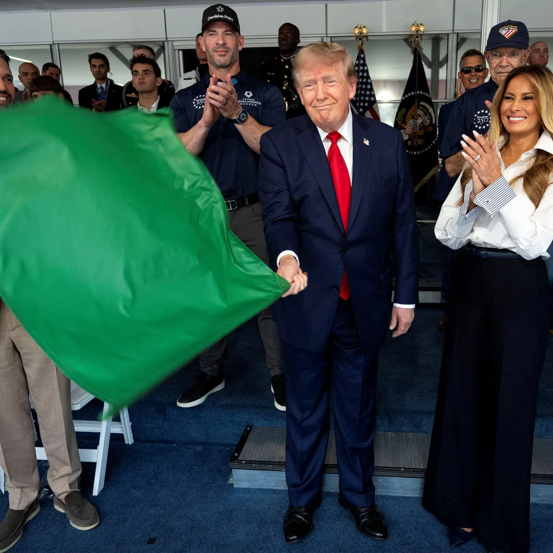 US President Donald Trump waves the green flag to start the race with First Lady Melania Trump at his side, during the Freedom 250 Grand Prix Race on the streets of Washington DC on Aug 23.