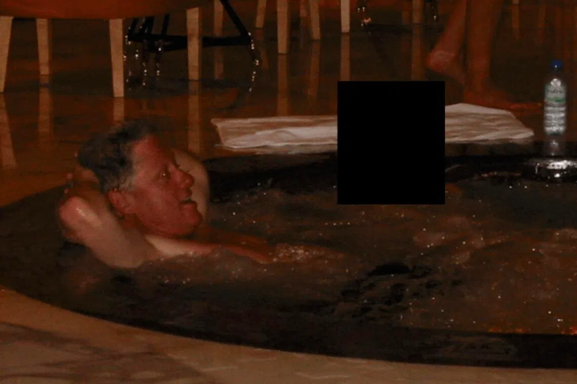 Bill Clinton in a hot tub with an unknown person, in an undated photo redacted and released by the US Department of Justice on Dec 19, 2025. 