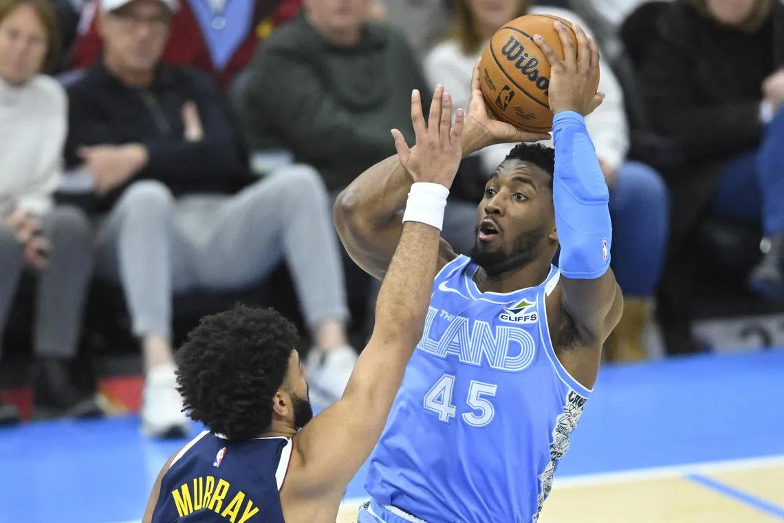 Cleveland Cavaliers guard Donovan Mitchell shoots beside Denver Nuggets guard Jamal Murray in the third quarter at Rocket Mortgage FieldHouse.