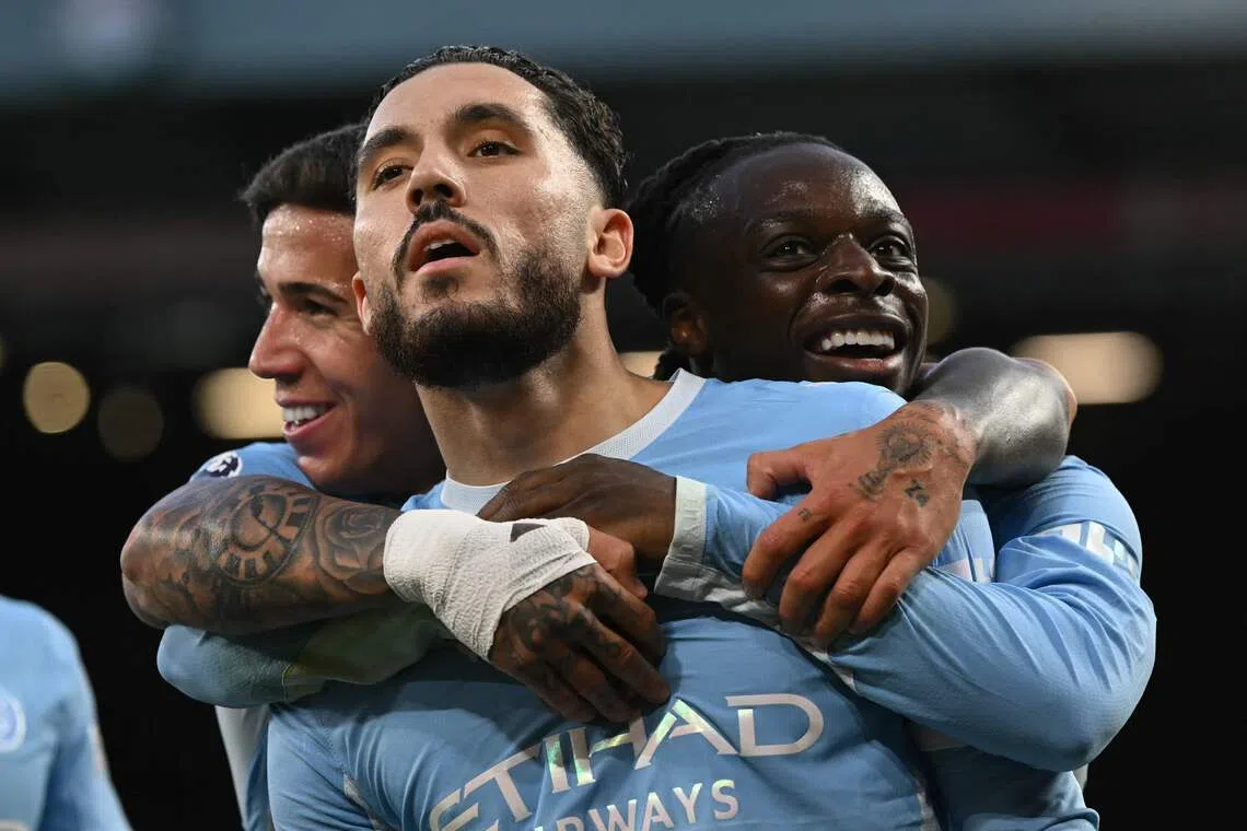 Manchester City’s French midfielder Rayan Cherki (centre) celebrates scoring the third goal with teammates Enzo Fernandez (left) and Jeremy Doku.