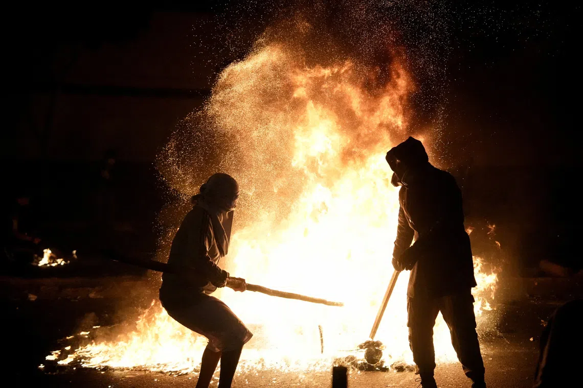 Demonstrators stand next to fire burning during a protest against rising crime, economic insecurity, and corruption, a day after President Jose Jeri presented his cabinet, in Lima, Peru, October 15, 2025. REUTERS/Angela Ponce