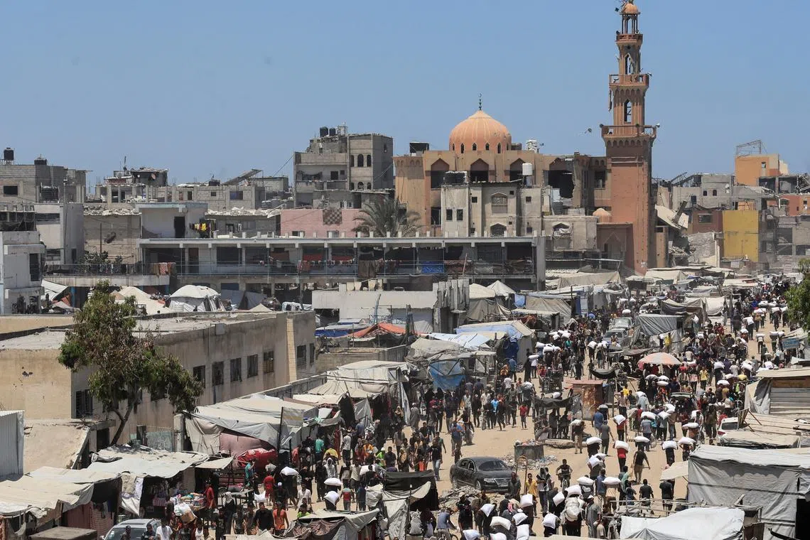 Palestinians gather to receive aid supplies in Khan Younis, in the southern Gaza Strip, on June 26.