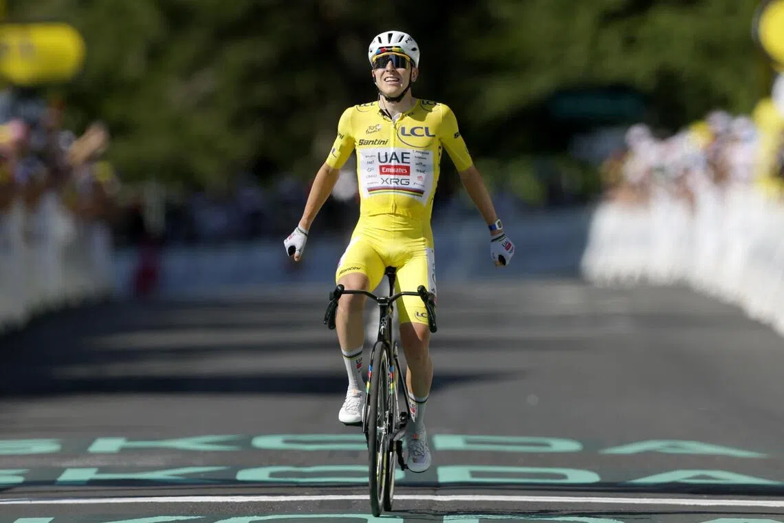 Slovenian cyclist Tadej Pogacar, of UAE Team Emirates XRG, celebrates as he crosses the finish line to win Stage 10 of the Tour de France.