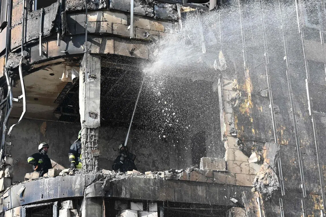 Ukrainian rescuers work to extinguish a fire in a damaged residential building following a drone attack in Kharkiv.