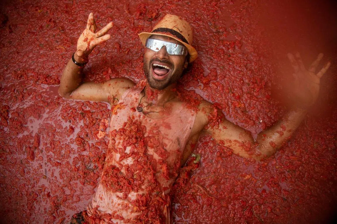 A reveller lying on a street flooded with tomato pulp during the "Tomatina" annual food-battle in the Spanish eastern town of Bunol, on Aug 30.