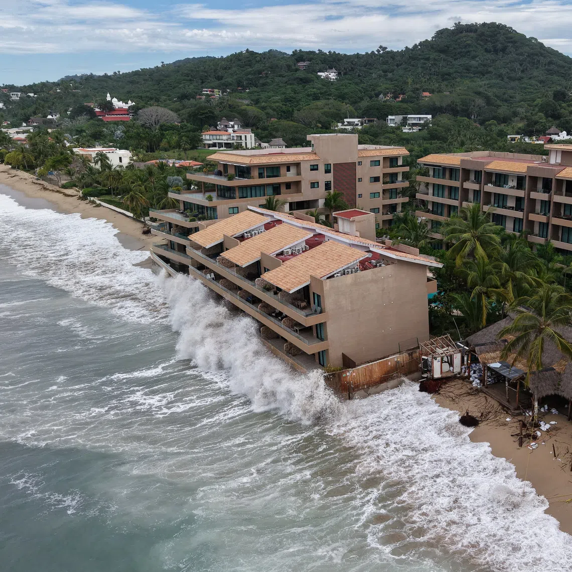 A drone view shows waves crash against beachfront buildings as Hurricane Simon remains off Mexico's Pacific coast, in San Francisco, Bahia de Banderas, Nayarit state, Mexico, October 12, 2026. REUTERS/Christian Ruano