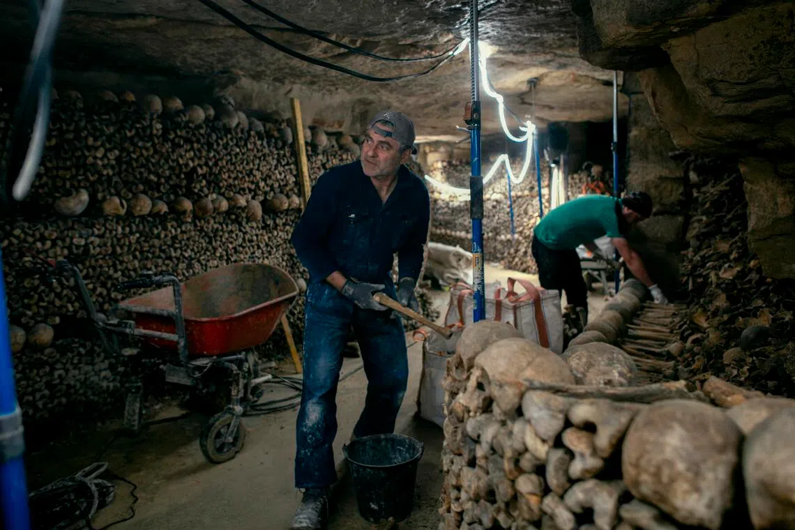 Mason Florent Bastaroli, left, at work restoring the catacombs in Paris, March 19, 2026. 
