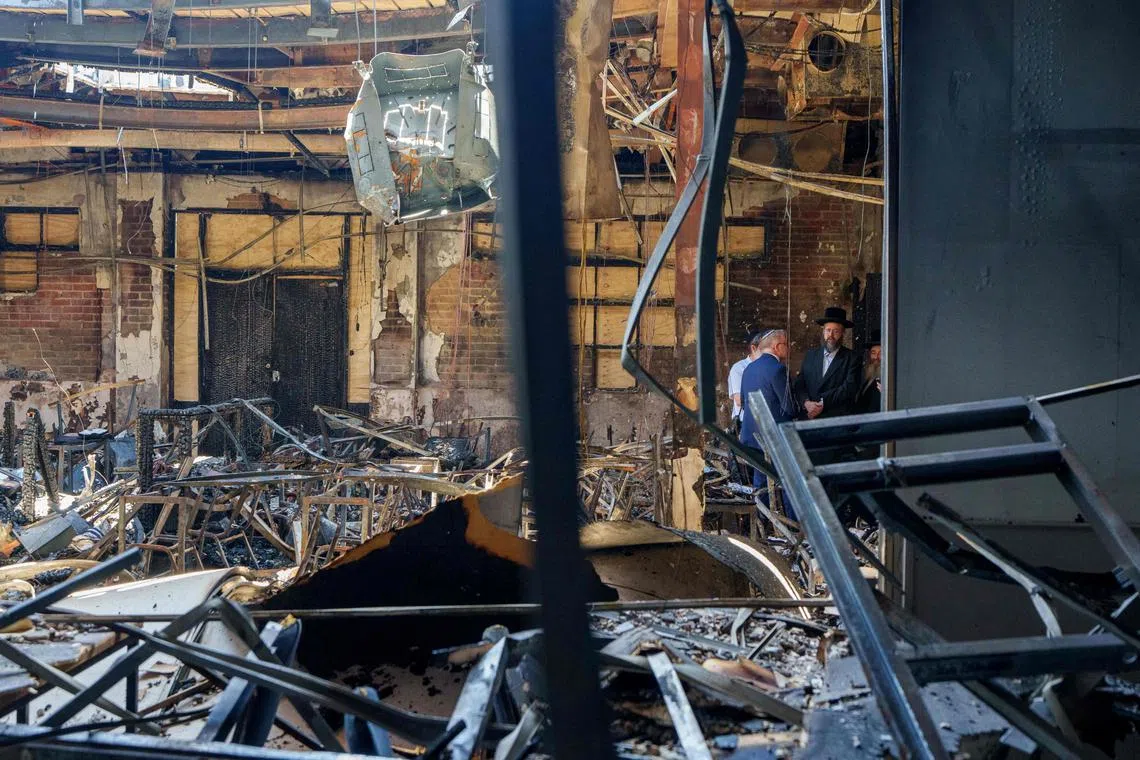 This handout photo taken and released by the Department of Prime Minister and Cabinet on Dec 10 shows Australia's Prime Minister Anthony Albanese (second from right) and Rabbi Shlomo Kohn (far right) visiting the Adass Israel Synagogue in Melbourne, which was set ablaze on Dec 6.