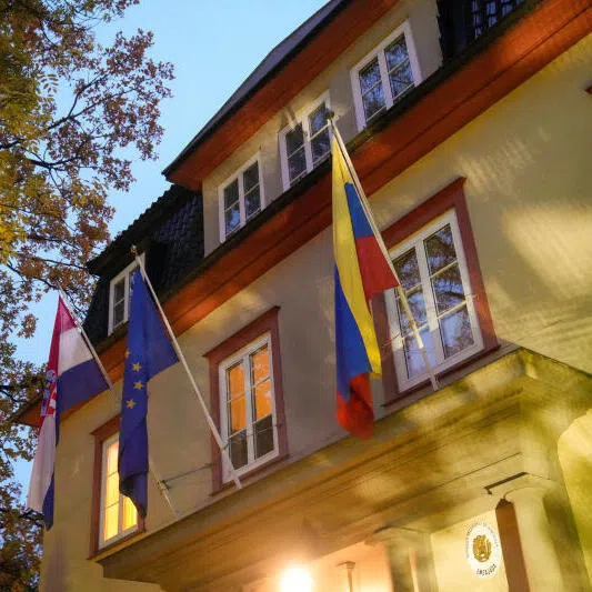 Flags hang from flagpoles attached to a building that hosts the embassies of Croatia and Venezuela in Oslo, Norway.