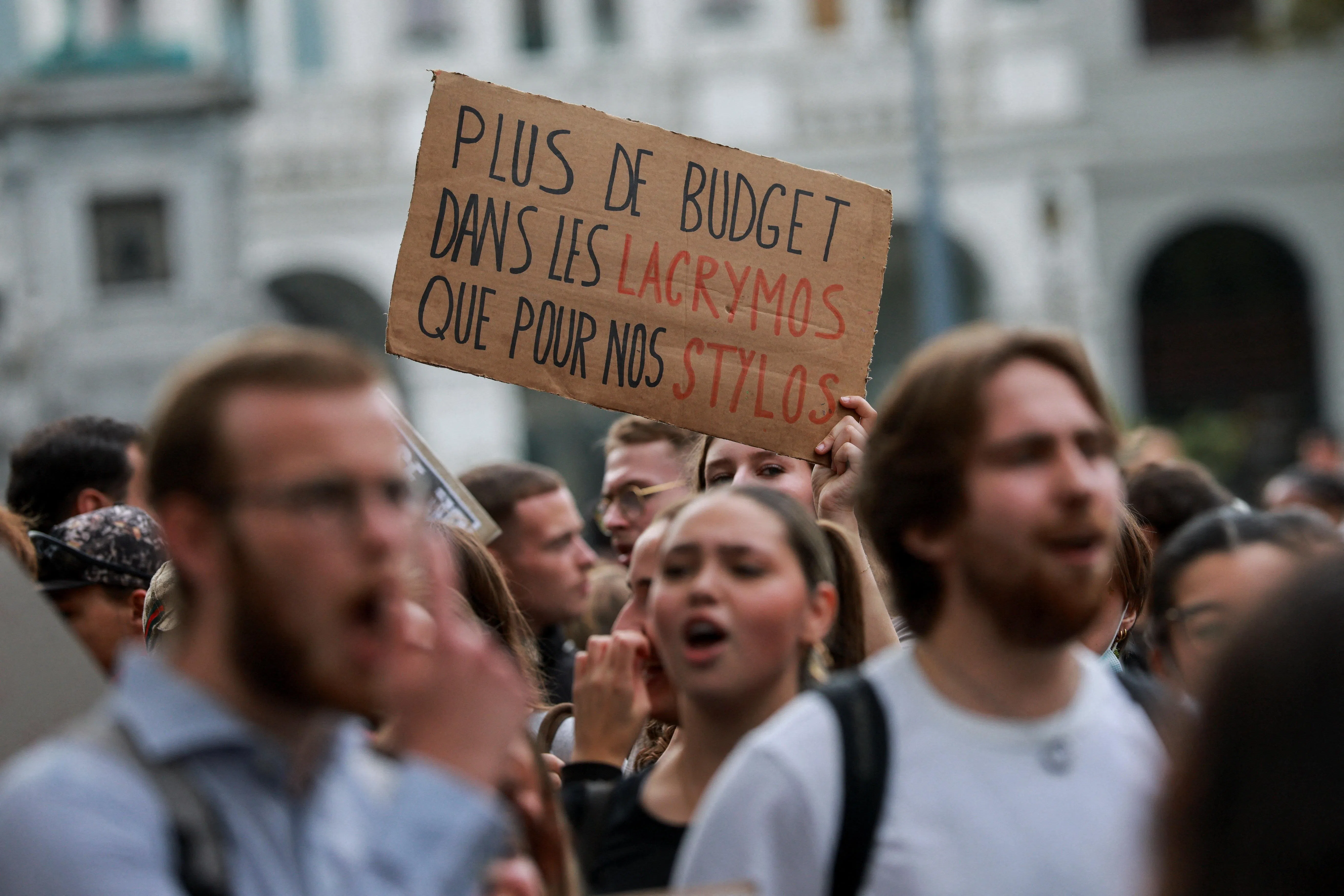 A person holding a placard that reads: “More budget for tear gas than for our pens”, as high school students take part in a street protest in Liege, Belgium, on Oct 7.