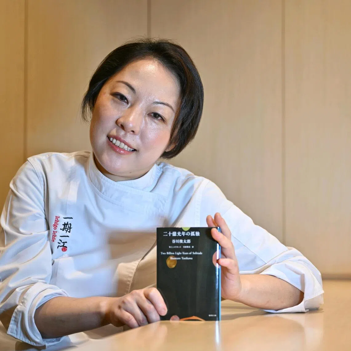 Chef Akane Eno of Ichigo Ichie restaurant, with the book she's reading, Two Billion Light-Years of Solitude by Shuntaro Tanikawa, on Sep 24, 2025.
