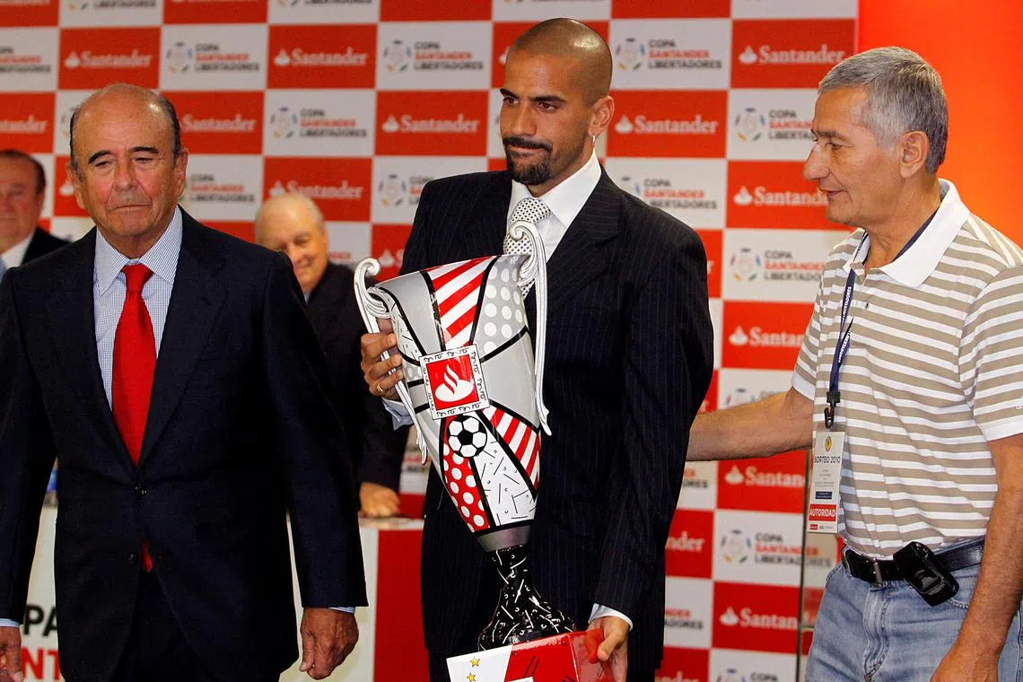 FILE PHOTO: Spain's Banco Santander Chairman Emilio Botin (L), Argentine soccer player Juan Sebastian Veron (C) and his father Juan Ramon Veron (R) attend a ceremony where Juan Sebastian Veron received the award as Most Valuable Player of the 2009 Copa Libertadores tournament in the headquarters of the South American Soccer Confederation (CONMEBOL) in Asuncion November 26, 2009. REUTERS/Jorge Adorno/File Photo