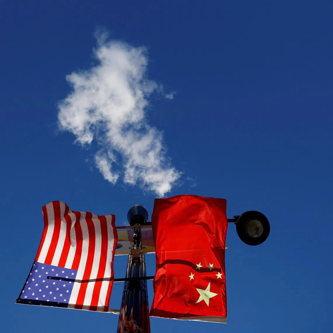 FILE PHOTO: The flags of the United States and China fly from a lamppost in the Chinatown neighborhood of Boston, Massachusetts, U.S., November 1, 2021. REUTERS/Brian Snyder/File Photo