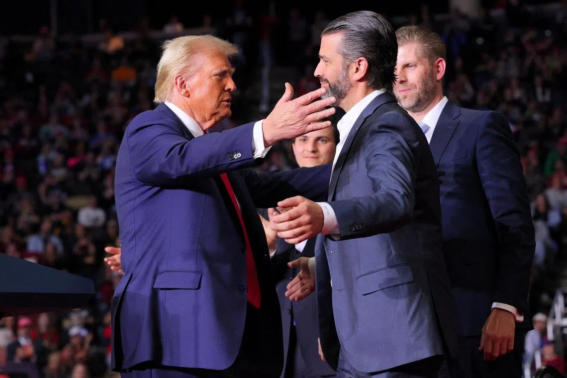 FILE PHOTO: Republican presidential nominee and former U.S. President Donald Trump approaches to embrace Donald Trump Jr at his campaign rally, at PPG Paints Arena in Pittsburgh, Pennsylvania, U.S., November 4, 2024. REUTERS/Brian Snyder/File Photo