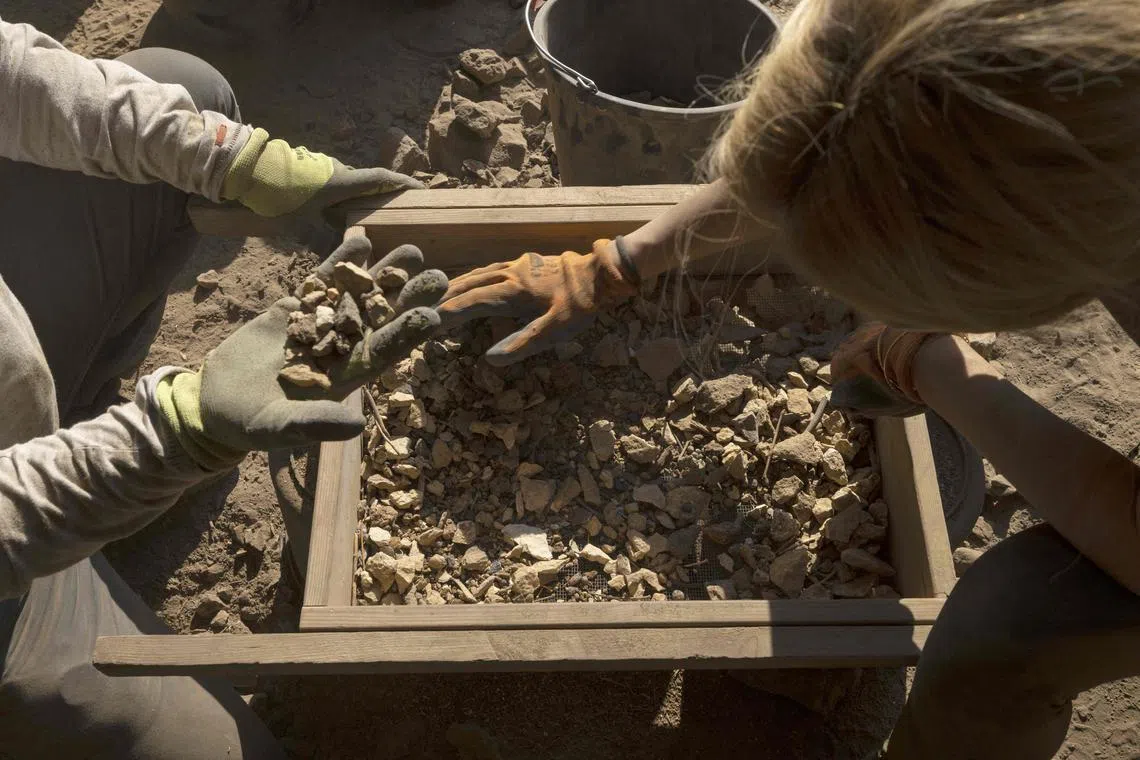 Members of the Israel Antiquities Authority (IAA) team sift soil at an excavation site in the Murabaat cave in the Judean Desert area near the Dead Sea, on December 28, 2022. In the cave, 180 documents written on papyri were previously discovered in which the name of the leader of the rebellion against the Romans, Shimon Bar Kochba, was mentioned for the first time. 