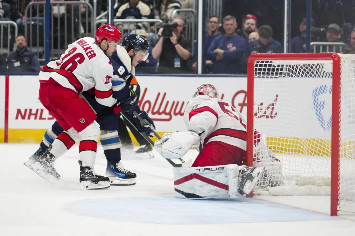 Nov 23, 2024; Columbus, Ohio, USA;  Carolina Hurricanes defenseman Sean Walker (26) skates for the puck against Columbus Blue Jackets defenseman Zach Werenski (8) as they collide with Carolina Hurricanes goaltender Pyotr Kochetkov (52) in the third period at Nationwide Arena. Mandatory Credit: Aaron Doster-Imagn Images/ File Photo