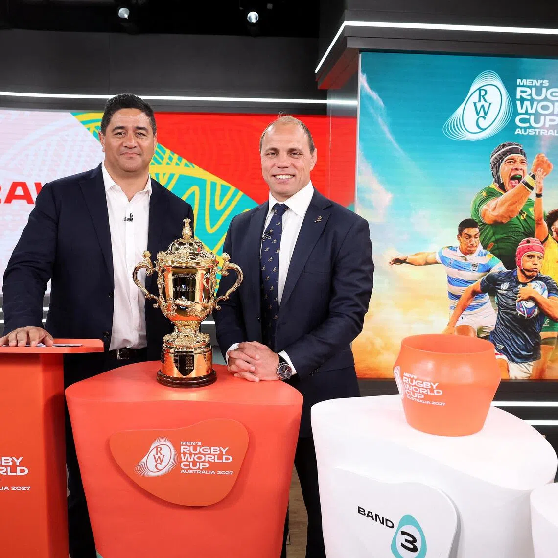 Australian former rugby union players Morgan Turinui and Phil Waugh pose with the Webb Ellis Cup during the 2027 Rugby World Cup draw at Channel Nine Studios in Sydney on Dec 3, 2025.
