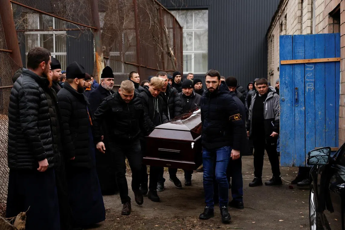 The coffin of Mr Mykhailo Korenovskyi, a Ukrainian boxing coach and father of two who was killed during a Russian missile attack, is carried by pallbearers during his funeral, in Dnipro, Ukraine, on Jan 17, 2023. 