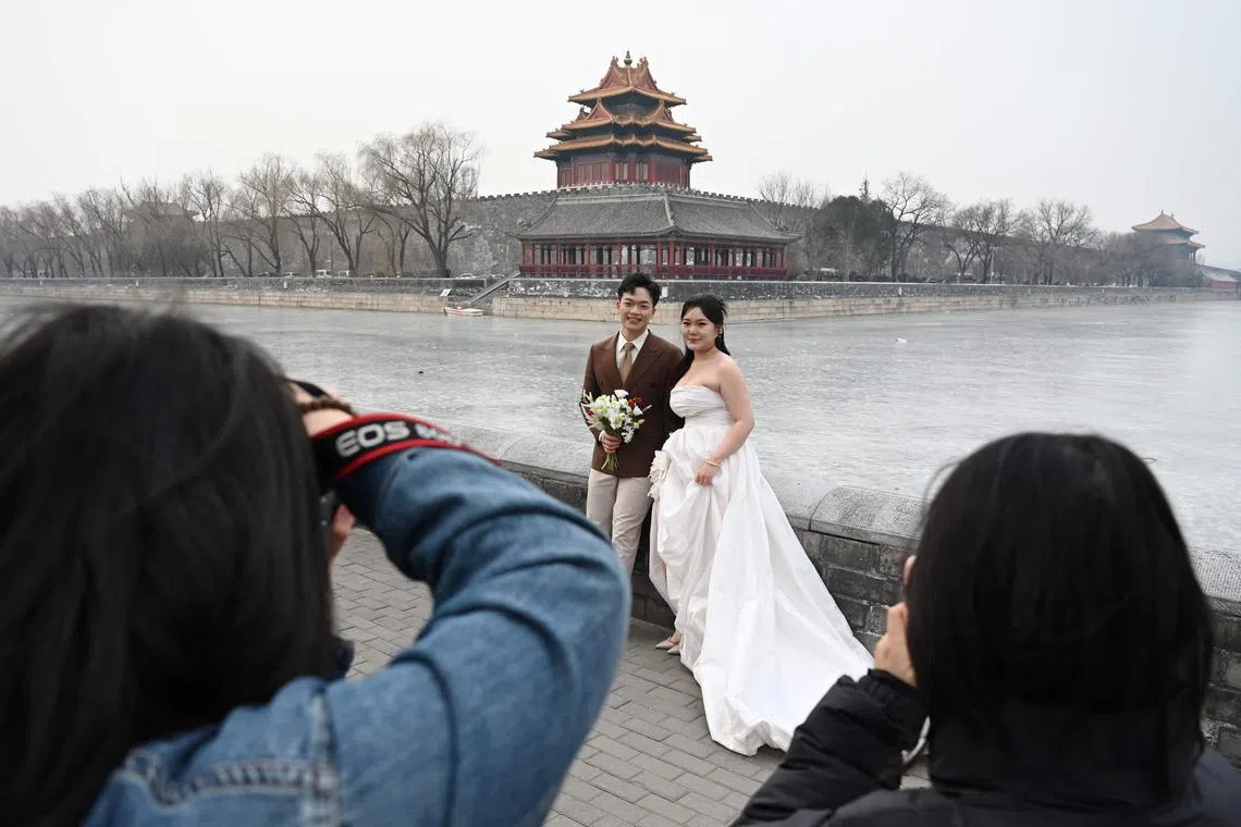 A couple poses for wedding photos outside the Forbidden City in Beijing on Feb 11.