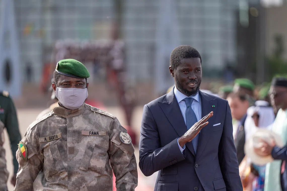 Senegal's President Bassirou Diomaye Faye waves as he walks along with Mali's junta leader Assimi Goita in Bamako, Mali May 30, 2024. Senegal's Presidency/Handout via REUTERS