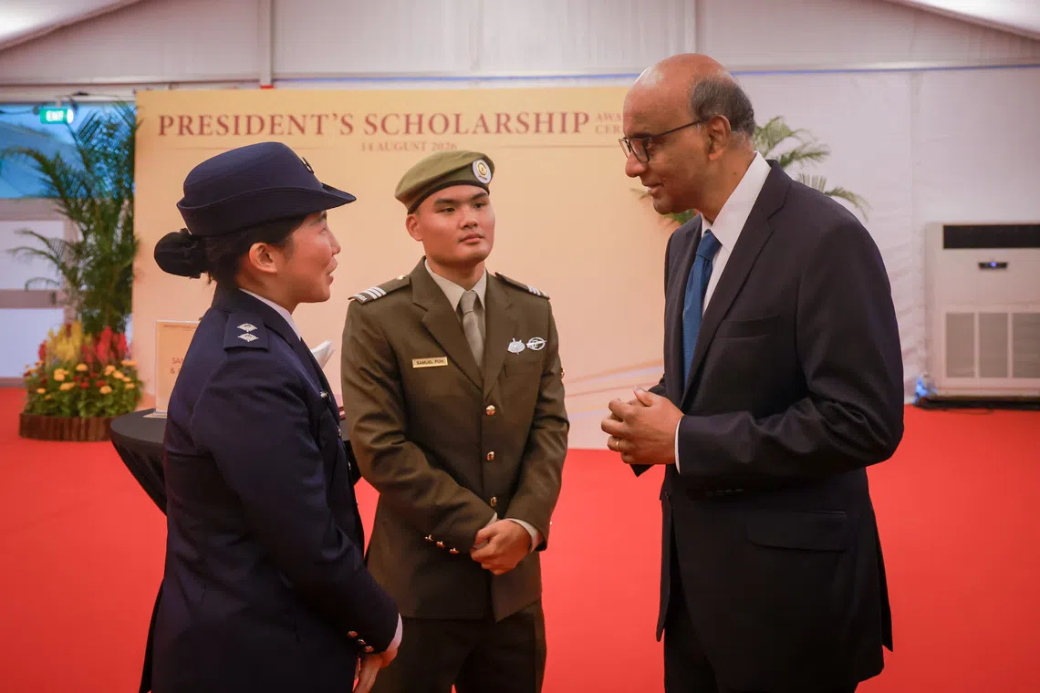 President Tharman Shanmugaratnam (right) speaking to President’s Scholarship recipients Samuel Poh (centre) and Charlene Tan at the Istana on Aug 14.