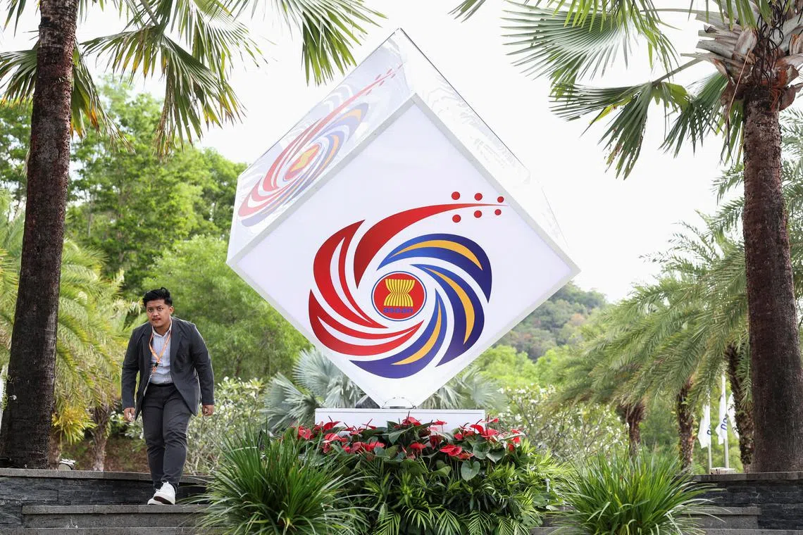 FILE PHOTO: A man walks next to the ASEAN logo during the ASEAN Foreign Ministers' Retreat in Langkawi, Malaysia, January 18, 2025. REUTERS/Hasnoor Hussain/File photo