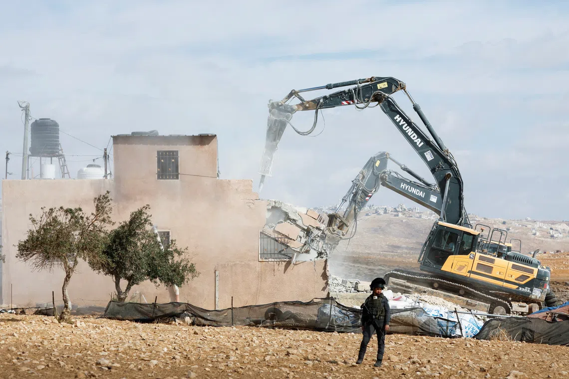 A member of the Israeli forces stands guard during the demolition of a Palestinian building near Hebron in the Israeli-occupied West Bank, October 5, 2026. REUTERS/Mussa Qawasma REFILE - QUALITY REPEAT TPX IMAGES OF THE DAY