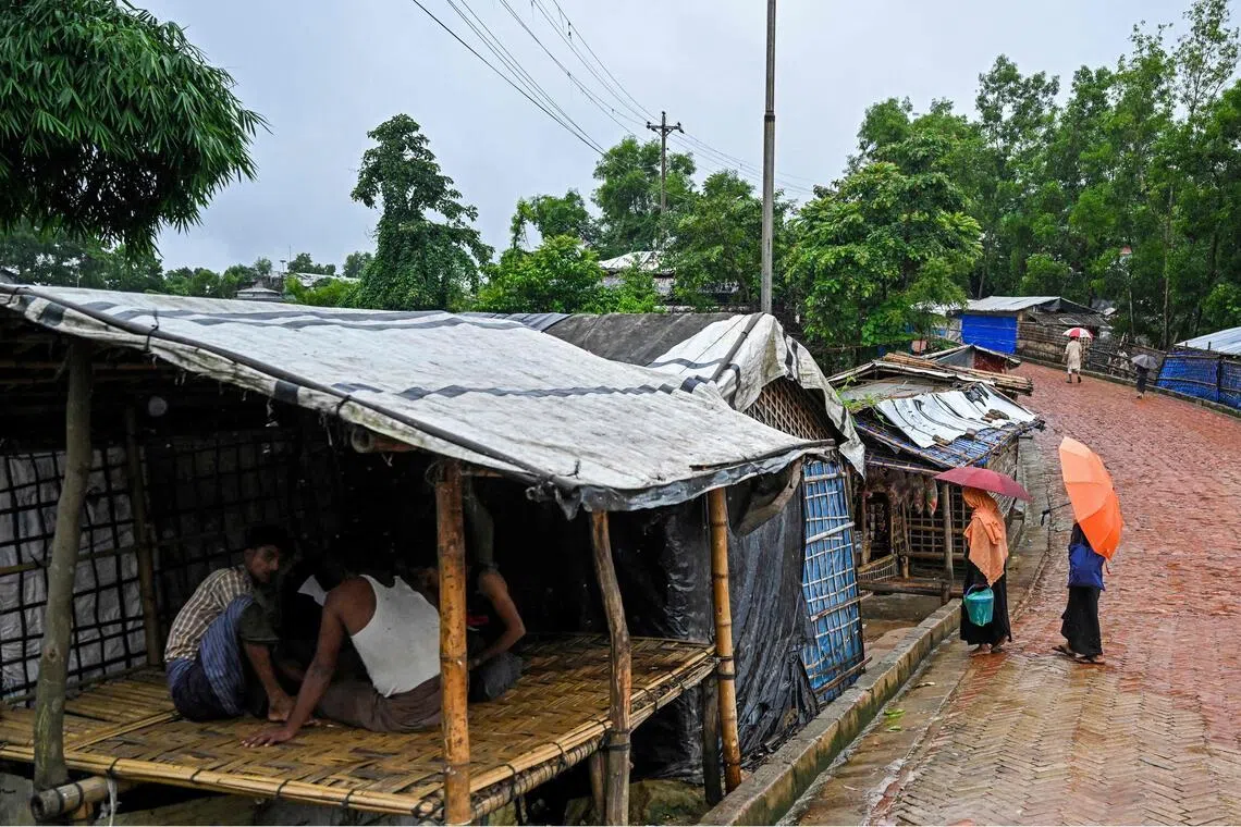 Rohingya women walk along a rain-soaked road at the Kutupalong refugee camp in Bangladesh’s Cox’s Bazar.