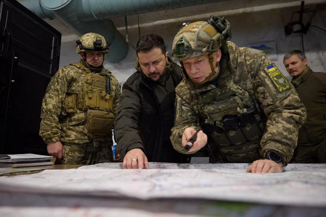 Ukrainian President Volodymyr Zelensky (centre) consults with Colonel-General Oleksandr Syrskyi.