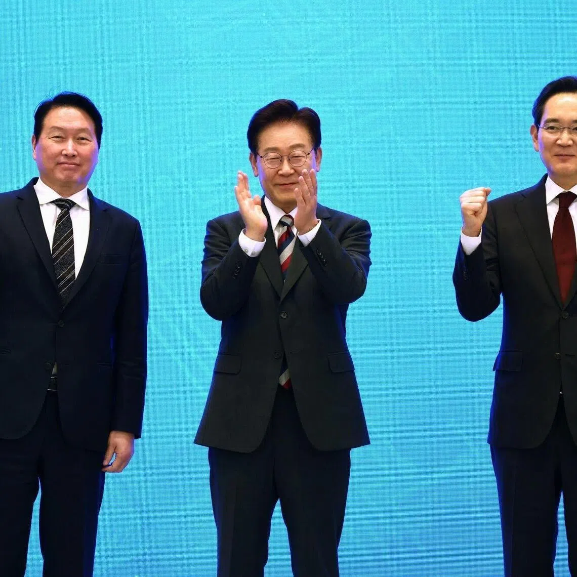 Chey Tae-won, chairman of SK Group, left, Lee Jae Myung, South Korea's president, center, and Jay Y. Lee, chairman of Samsung Electronics Co., pose for photographs during a news conference at the presidential Blue House in Seoul, South Korea, on Monday, June 29, 2026. South Korea unveiled an ambitious plan aimed at cementing its status as a technological powerhouse, with companies led by Samsung Electronics Co. and SK Hynix Inc. initiating large-scale investments in memory chips, data centers and robotics. Photographer: SeongJoon Cho/Bloomberg