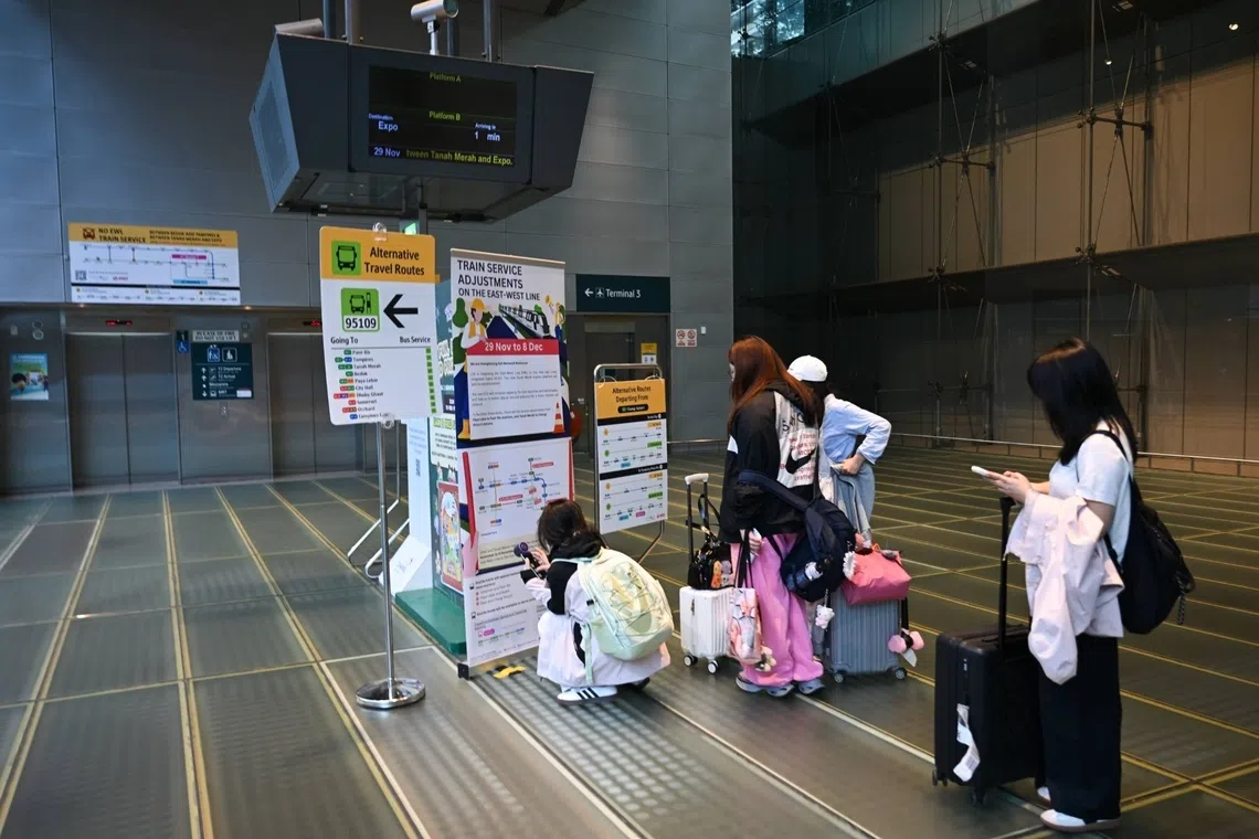 Tourists viewing signage about adjustments on the East West Line, at Changi Airport MRT station on Nov 29.