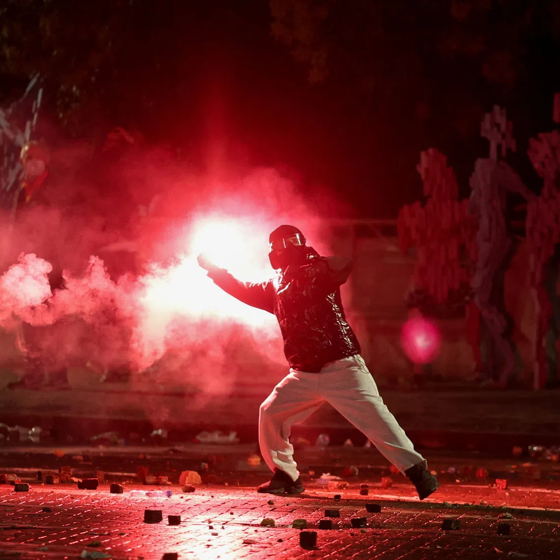 A demonstrator swings a flare amid clashes during an anti-government protest by students in Tirana, Albania, October 17, 2026. REUTERS/Louisa Gouliamaki