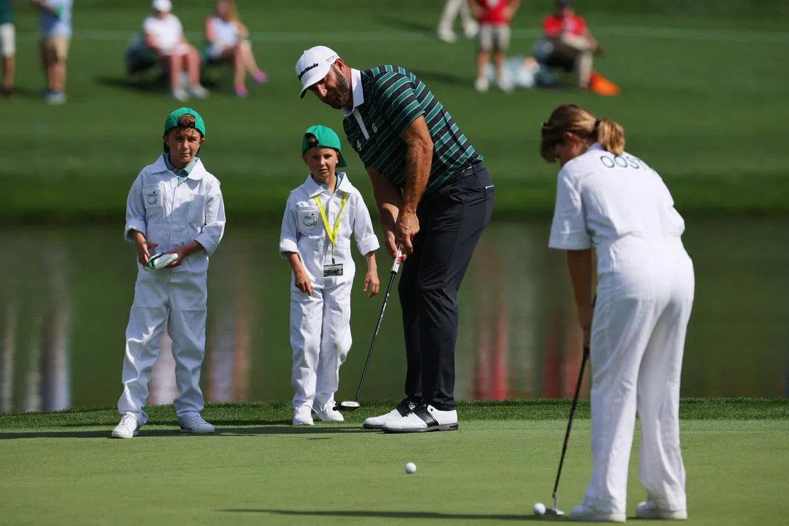 Dustin Johnson with hi children Tatum and River on the third hole green during the par-3 contest at the Masters. He has won at least US$35 million on the LIV Golf tour. 