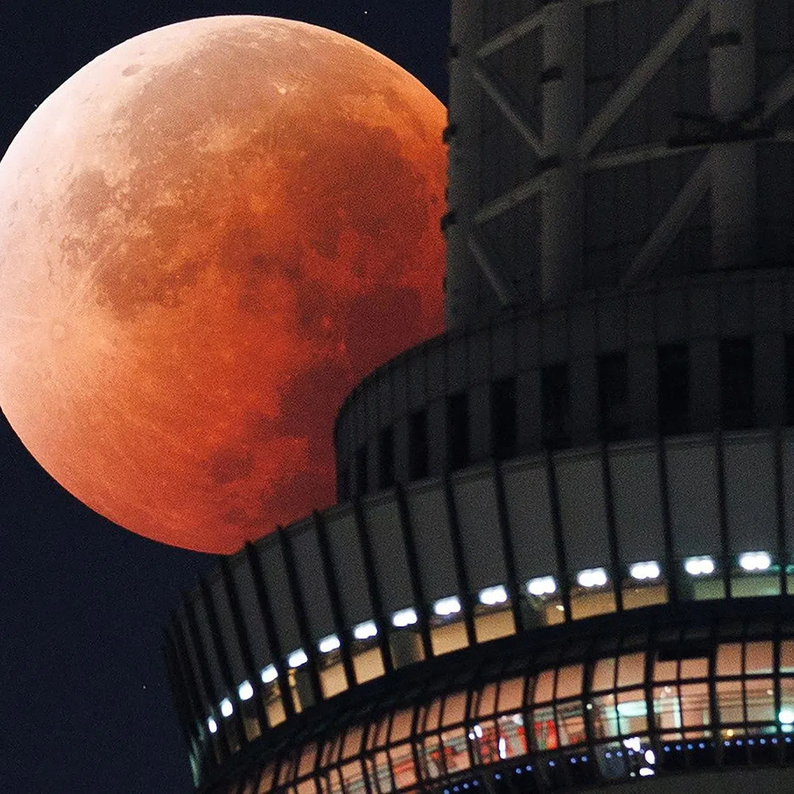 The moon appears from behind the Tokyo Skytree during a total lunar eclipse in the middle of the night above the Japanese capital early on Sept 8, 2025. Stargazers enjoyed a "Blood Moon" overnight on SepT 7 during a total lunar eclipse visible across Asia and swathes of Europe and Africa. 