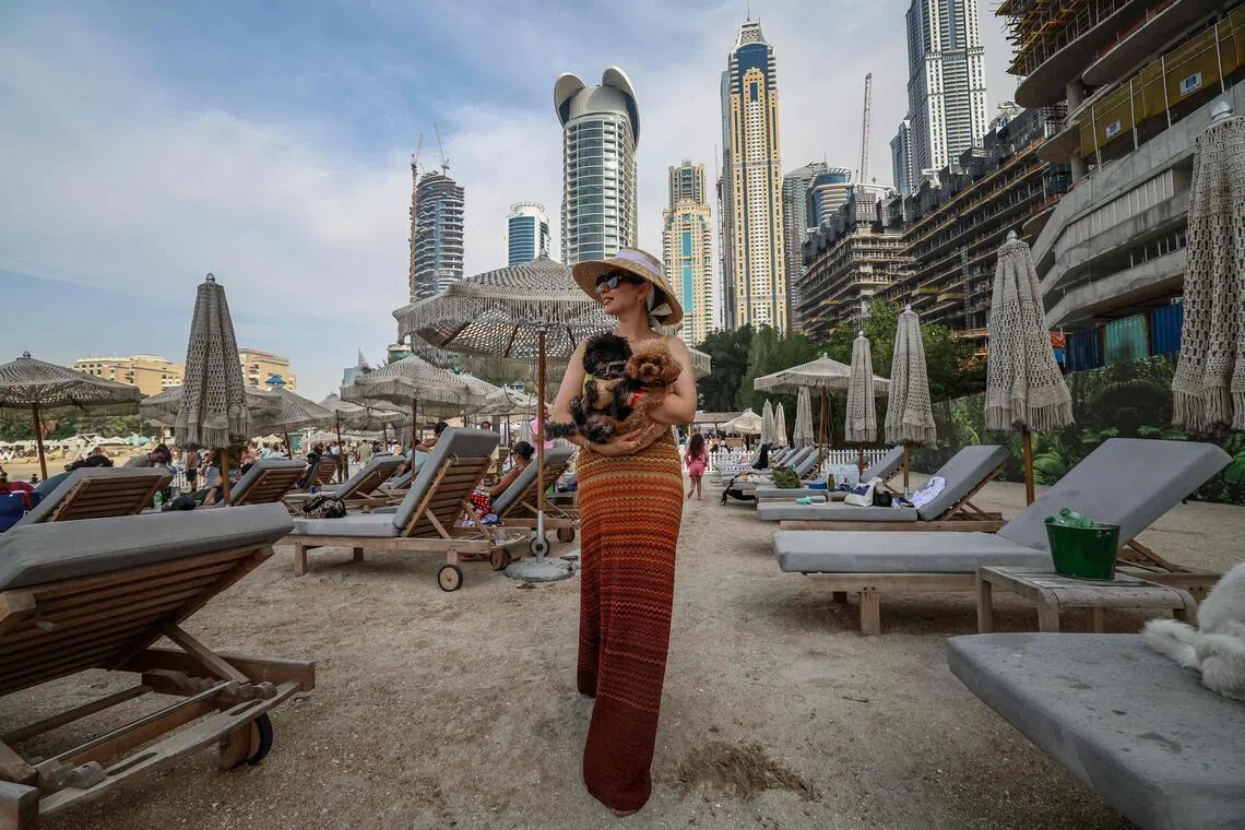 A woman poses for a picture with her dogs during the Barkfest dog festival at Barasti Beach in Dubai on April 4. 