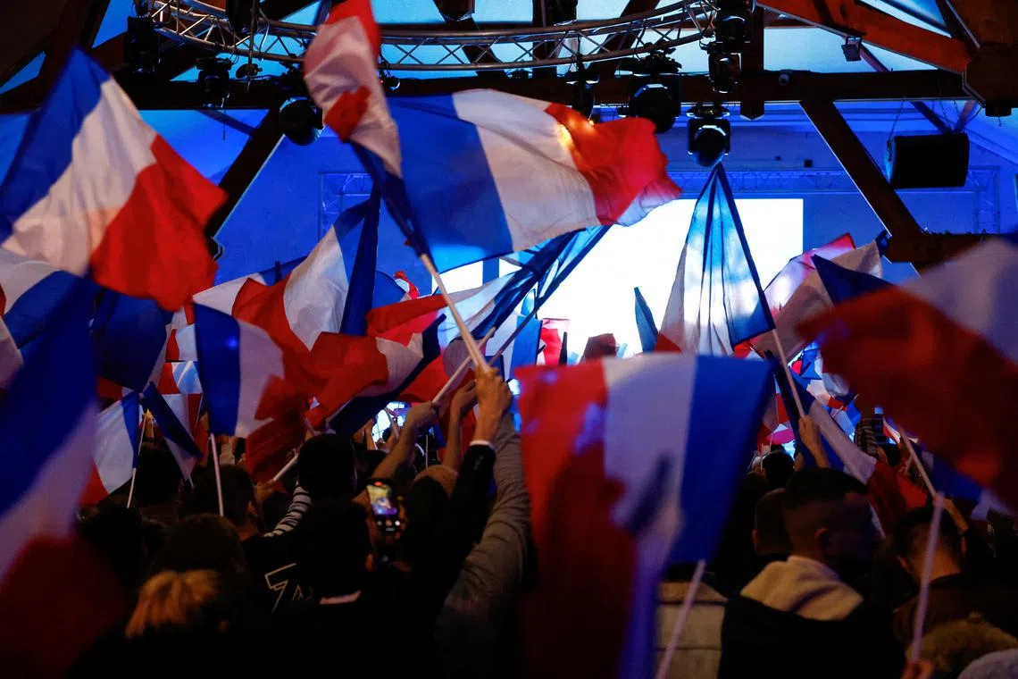 Supporters of the French far-right National Rally (Rassemblement National - RN) party wave French flags, during a political rally in Etrepagny, France, December 15, 2024. REUTERS/Stephanie Lecocq/File Photo