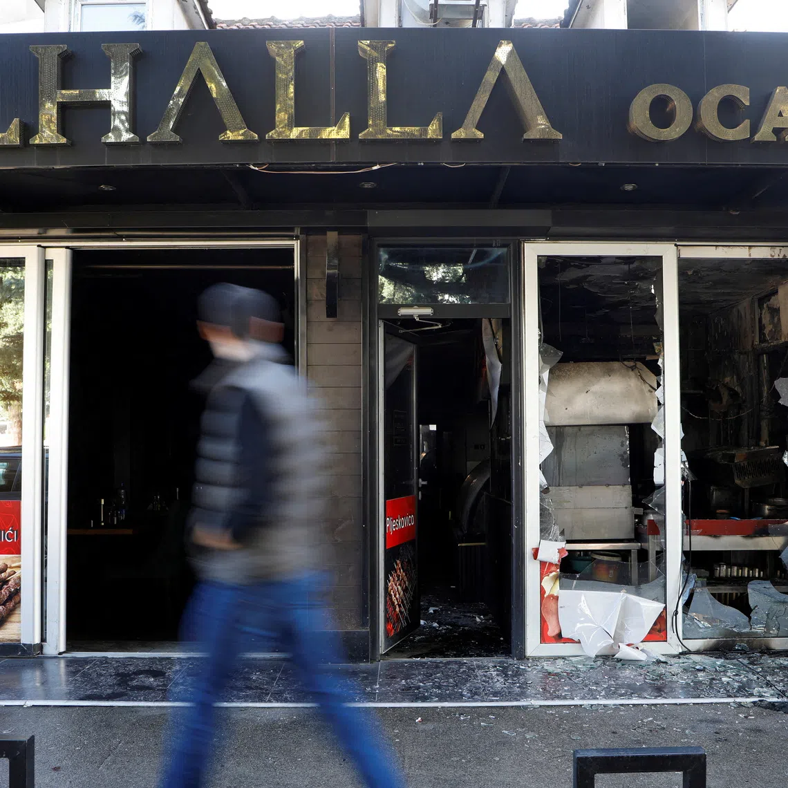 FILE PHOTO: A man looks as he walks past a demolished Turkish owned restaurant in downtown, after a man was stabbed and wounded in a late-night incident in Podgorica, Montenegro, October 27, 2025. REUTERS/Stevo Vasiljevic/File Photo