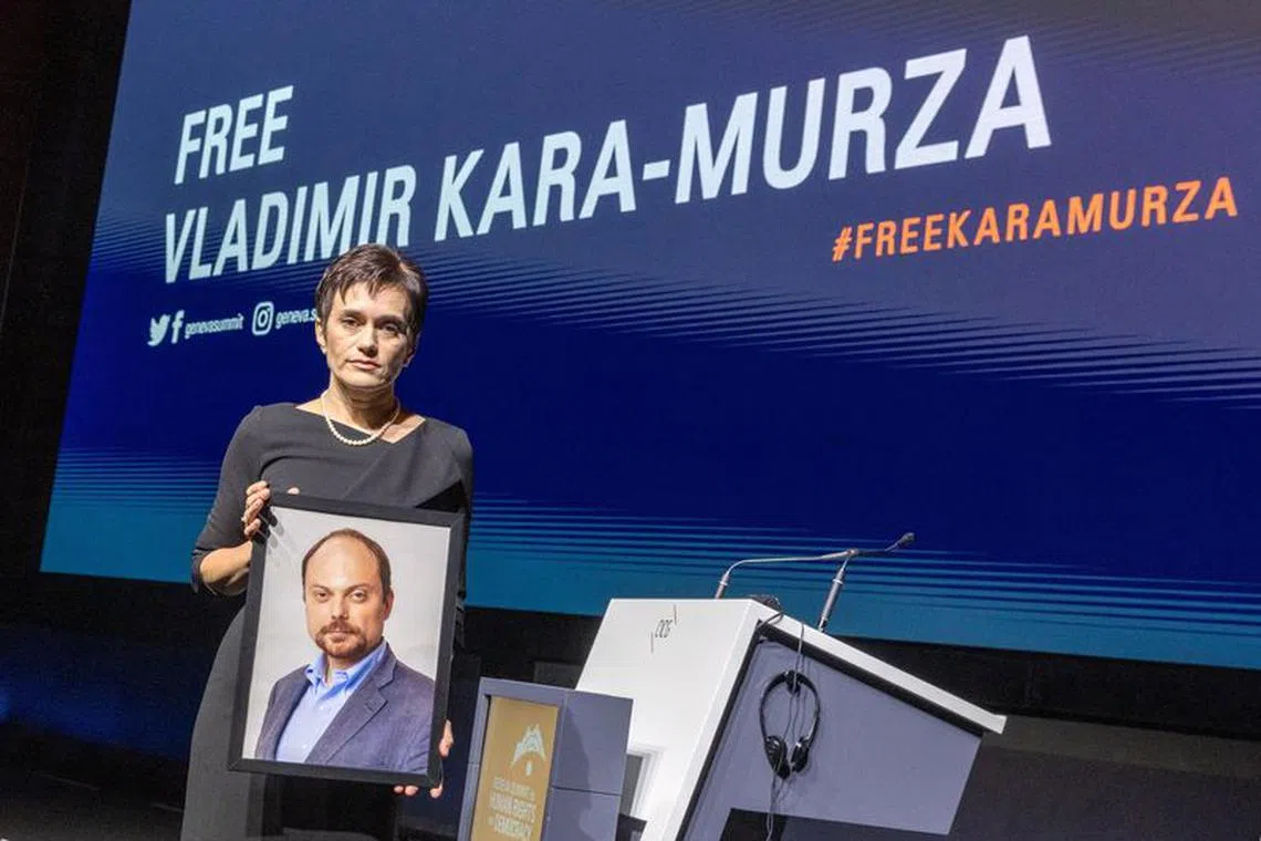 Evgenia Kara-Murza, wife of jailed Russian opposition figure Vladimir Kara-Murza, poses with a picture of her husband after her address for the opening of the Geneva Summit for Human Rights and Democracy in Geneva, Switzerland May 17, 2023. REUTERS/Denis Balibouse/File Photo