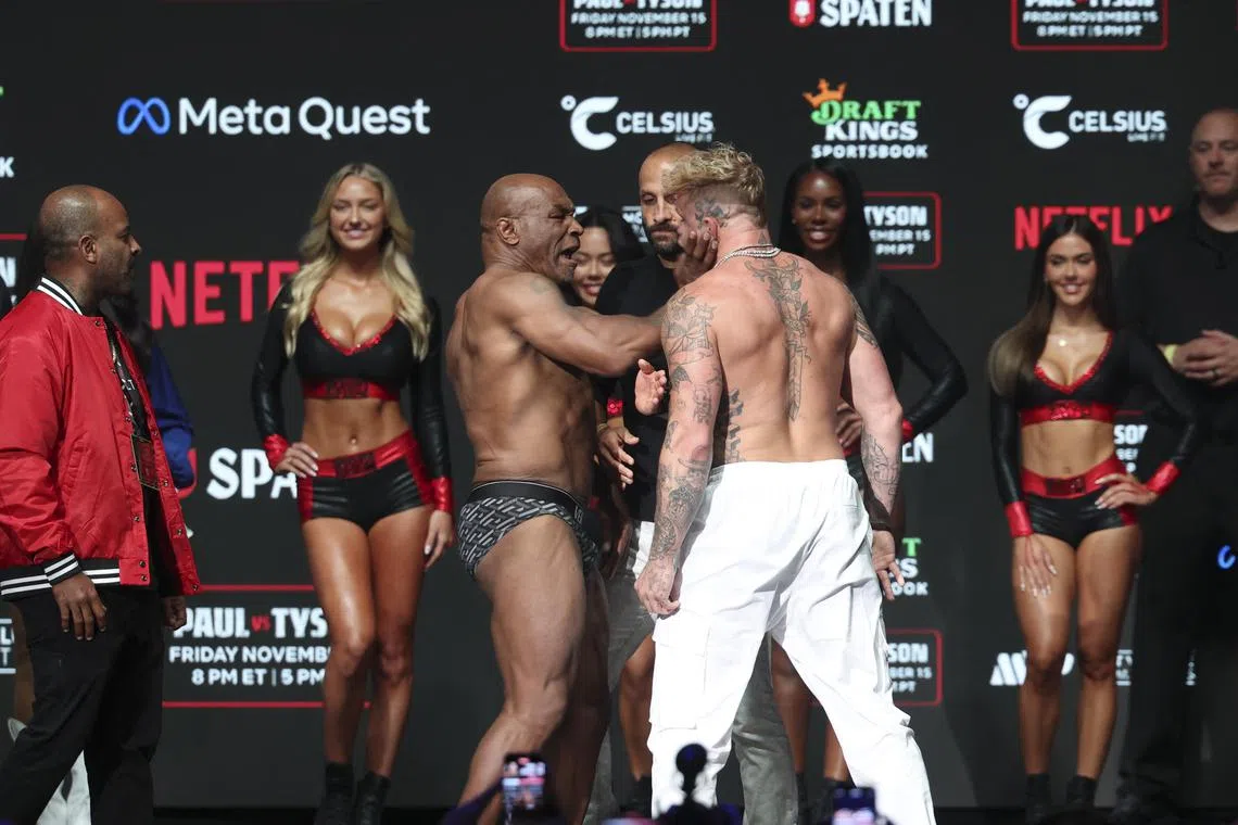 Nov 14, 2024; Irving, TX, USA;  Mike Tyson (left) slaps Jake Paul (right) after weighing in at the Toyota Music Factory.  Mandatory Credit: Kevin Jairaj-Imagn Images